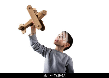 Kid plays with a wooden toy airplane. Isolated on white background Stock Photo