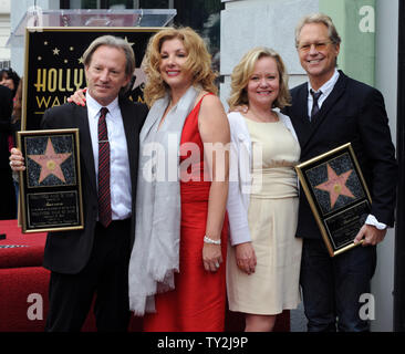 Dewey Bunnell (L) and Gerry Beckley (R), members of the classic rock group and Grammy Award-winning duo America, hold replica plaques after they were honored with the 2,459th star on the Hollywood Walk of Fame during an unveiling ceremony in Los Angeles on February 6, 2012. Bunnell and Beckley are pictured with their wives Penny (2nd-L) and Kathy (3rd-L).  UPI/Jim Ruymen Stock Photo