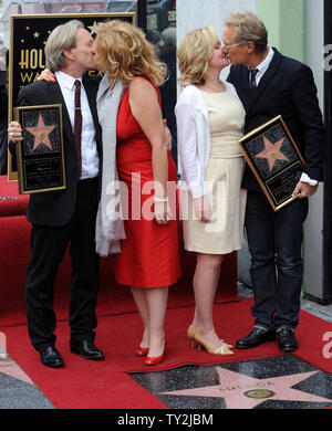 Dewey Bunnell (L) and Gerry Beckley (R), members of the classic rock group and Grammy Award-winning duo America, hold replica plaques after they were honored with the 2,459th star on the Hollywood Walk of Fame during an unveiling ceremony in Los Angeles on February 6, 2012. Bunnell and Beckley are pictured with their wives Penny (2nd-L) and Kathy (3rd-L).  UPI/Jim Ruymen Stock Photo