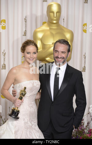Jennifer Lawrence poses with Jean Dujardin as she holds her Oscar for Performance by an Actress in a Leading Role for 'Silver Linings Playbook' backstage at the 85th Academy Awards at the Hollywood and Highlands Center in the Hollywood section of Los Angeles on February 24, 2013. UPI/Phil McCarten Stock Photo