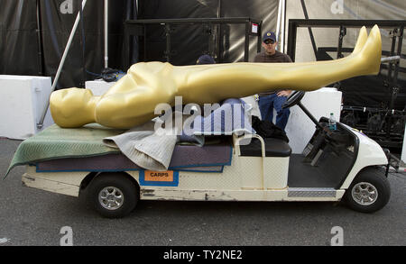 A worker waits with an oversized 'Oscar statue' before it is erected near the main entrance in preparation for the 84th Academy Awards at the Kodak Theater in the Hollywood section of Los Angeles on February 25, 2012.   UPI/Gary C. Caskey Stock Photo