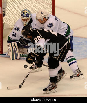 Vancouver Canucks goalie Cory Schneider, left, stops a shot by ...