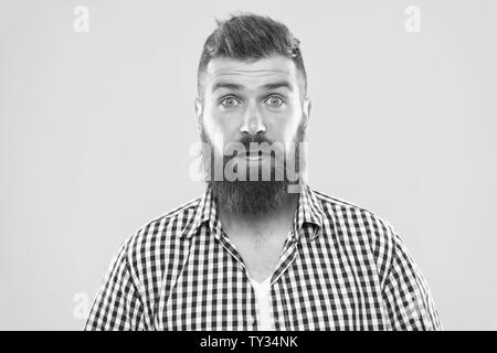 Hipster with beard and mustache emotional surprised expression. Rustic surprised macho. Surprising news. Man bearded hipster wondering face yellow background close up. Guy surprised face expression. Stock Photo