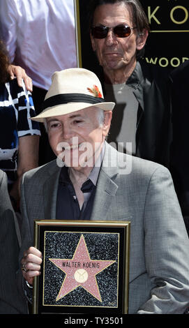 Actor Walter Koenig holds a replica plaque during an unveiling ceremony honoring him with the 2,479th star on the Hollywood Walk of Fame in Los Angeles on September 10, 2012.  Koenig is the final member of the 'Star Trek' television show to receive a star. Looking on rear is actor Leonard Nimoy.  UPI/Jim Ruymen Stock Photo