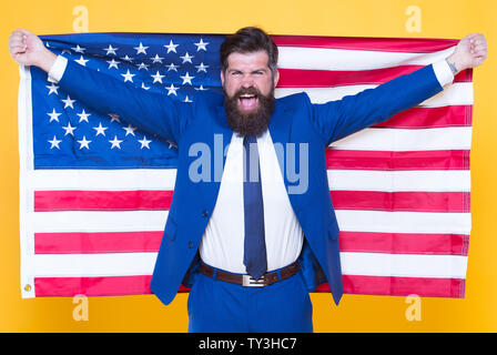 American by birth. Rebel by choice. Confident businessman handsome bearded man in formal suit hold flag USA. Successful businessman well groomed appearance. Business people. Businessman concept. Stock Photo