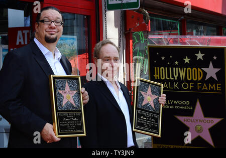 Penn Jillette (L) and Raymond Teller of the comedy magic duo Penn & Teller hold replica plaques, during an unveiling ceremony, honoring the pair with the 2,494th star on the Hollywood Walk of Fame in Los Angeles on April 5, 2013.  UPI/Jim Ruymen Stock Photo