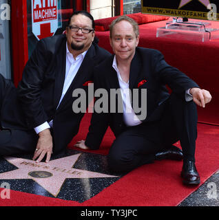 Penn Jillette (L) and Raymond Teller of the comedy magic duo Penn & Teller sit atop their star, during an unveiling ceremony, honoring the pair with the 2,494th star on the Hollywood Walk of Fame in Los Angeles on April 5, 2013.    UPI/Jim Ruymen Stock Photo