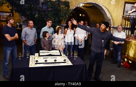 Cast members Eric Christian Olsen, Chris O'Donnell, Linda Hunt, Barrett Foa, Renee Felice Smith, Daniela Ruah and Miguel Ferrer (L-R), listen to remarks by cast member L.L. Cool J, during a cake-cutting ceremony to celebrate CBS' 'NCIS: Los Angeles' filming of their 100th episode held on the set at Paramount Studios in Los Angeles on August 23, 2013.  UPI/Jim Ruymen Stock Photo