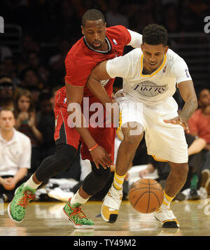 Miami Heat shooting guard Dwyane Wade, left, and Los Angeles Lakers small forward Nick Young, right, battle for the ball in the second half at Staples Center in Los Angeles on December 25, 2013. The Heat won 101-95. UPI/Lori Shepler Stock Photo