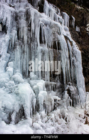 Beautiful icicles form as the water up in the mountains freezes . Stunning winter scene.Awesome texture, amazing ice formed shapes. Waterfalls created Stock Photo