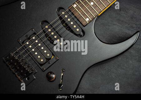 Black electric guitar on black cement floor. Top view and copy space for text. Concept of rock music. Stock Photo