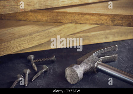 Close up hammer and screw in lumber stacking background. Copy space for text. Concept of carpenter or construct. Stock Photo