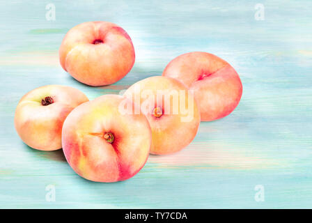 Saturn peaches on a teal background with copy space Stock Photo