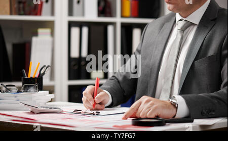 Businessman working and calculating, reads and writes reports. Office employee, table closeup. Business financial accounting concept. Stock Photo