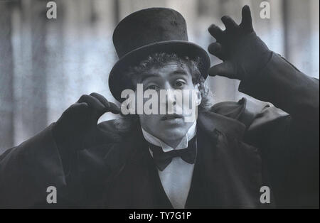 1980s, close-up of a male street entertainer wearing a dress suit, a top hat and cloak, with black gloves, England, UK. Stock Photo