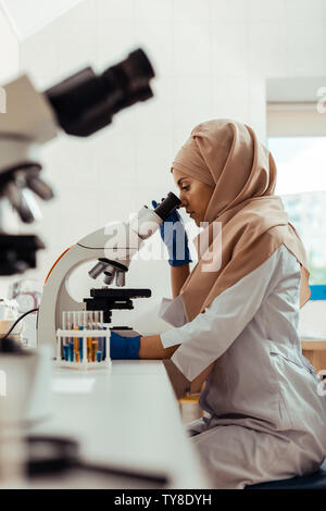 Serious thoughtful woman studying test samples in the bio lab Stock Photo