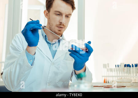 Serious intelligent man using a metal stick Stock Photo
