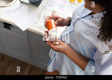 Pregnant woman going to take some vitamins. Stock Photo