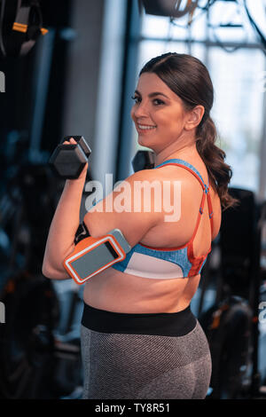 Overweight woman feeling positive while working out in gym Stock Photo