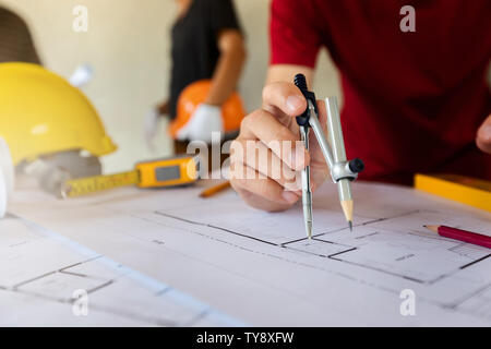 An architect or engineer working on blueprint, An architect or engineer uses a divider gauge on the blueprint., architectural concept Stock Photo