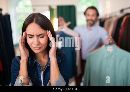 Lovely woman having headache during shopping with a husband. Stock Photo