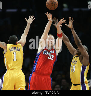Los Angeles Clippers center Chris Kaman, center, passes the ball away as Los Angeles Lakers guard Jordan Farmar, left, andr D.J. Mbenga , right, defend in the first half of a NBA basketball game in Los Angles on October 27, 2009.    UPI/Lori Shepler Stock Photo