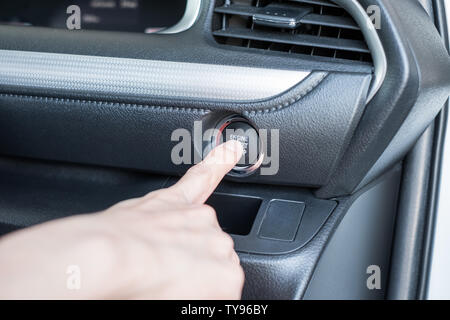 Driver finger pressing start engine car on control panel Stock Photo