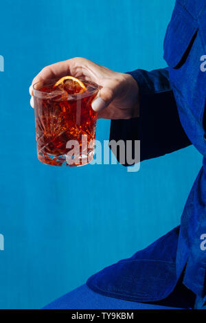 Woman and Negroni cocktail, with gin, bitter and vermouth. Colorful and trendy. Stock Photo