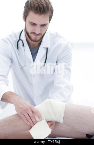 doctor bandaging patient knee Stock Photo