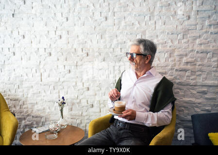 Senior man having a cup of coffee in the bar Stock Photo