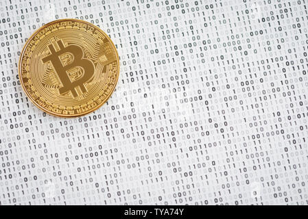 Crypto currency coin - golden Bitcoin on black and white binary 1 and 0 background Stock Photo