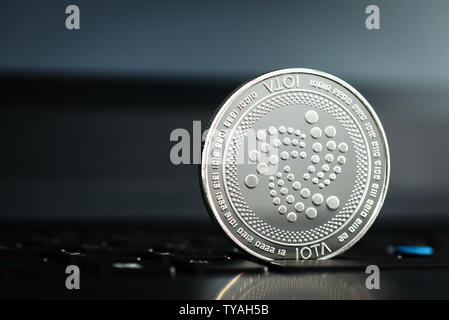 Crypto currency coin - IOTA on dark laptop keyboard Stock Photo