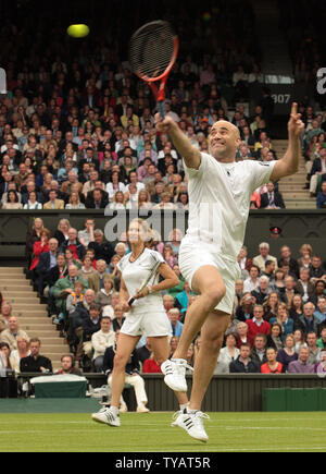 American tennis star Andre Agassi volleys the ball during a mixed doubles match with wife Steffi Graf against Britain Tim Henman and Kim Clijsters. The match was played to celebrate the first game on the new Wimbledon center court with the roof fully closed on Sunday May 17 2009. (UPI Photo/Hugo Philpott) Stock Photo