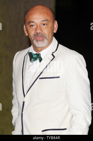 French shoe designer Christian Louboutin poses with his award at