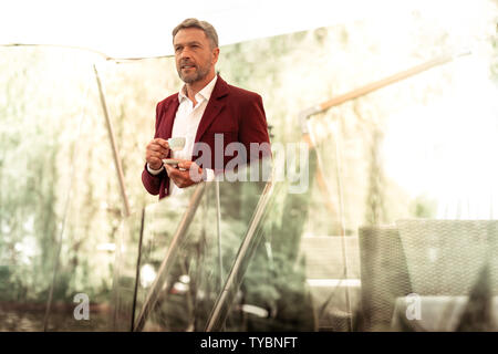 Businessman waiting for his wife while standing outside in restaurant Stock Photo