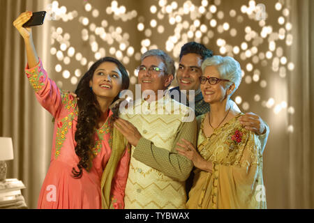 Indian family taking selfie or self photograph at home on diwali festival Stock Photo