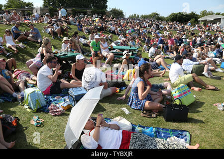 Visitors to Wimbledon enjoy the sunshine on day three of the 2015 Wimbledon championships, London on July 01, 2015. .Photo by Hugo Philpott/UPI. Stock Photo