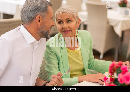 Mature woman with facial wrinkles looking at handsome husband Stock Photo