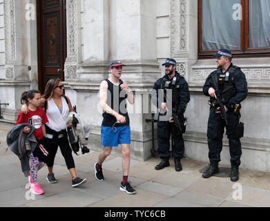 Tourists walk past armed policeman on the day the United Kingdom elected a new Prime Minister, Theresa May, on June 9, 2017 in London. Conservative leader  May has been forced to form a coalition with the Democratic Unionist Party to have a majority in Parliament.     Photo by Hugo Philpott/UPI Stock Photo
