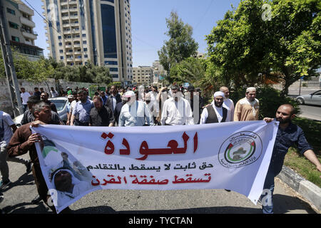 Gaza City, Palestinian Territories. 26th June, 2019. Palestinians hold a banner during a protest against the US-sponsored conference on Palestinian economic development in Bahrain. The two-day meeting aims at raising 50 billion dollars in investment over 10 years, but Palestinian leaders' refusal to take part is casting serious doubt about the usefulness of the event, called Peace to Prosperity Workshop. Credit: Mohammed Talatene/dpa/Alamy Live News Stock Photo