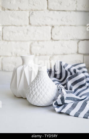 Two white ceramic vases and striped cloth on white background Stock Photo