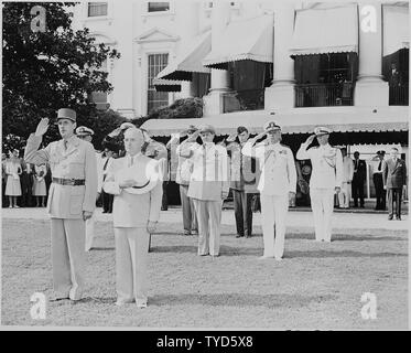Photograph of President Truman and French President Charles de Gaulle, during welcoming ceremonies on the White House lawn, with officers saluting in the background. Stock Photo