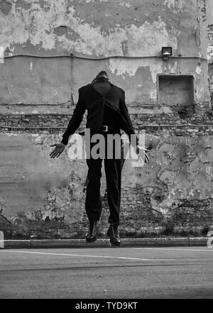 Depressed lonely man jumping and wanting to fly and travel from problem. Business concept of free. Outdoor portrait. Black and white Stock Photo