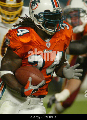 Miami Dolphins runningback Ricky Williams (34) takes the andoff from  Dolphins quarterback Gus Frerotte (11) against the Tenneessee Titans  December 24, at Dolphins Stadium in Miami Fl. The Miami Dolphins beat the