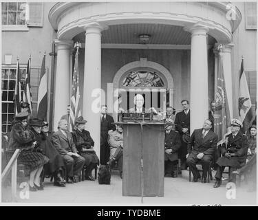 Photograph of President Truman delivering an address at the dedication of Franklin D. Roosevelt's home at Hyde Park, New York as a national shrine, on the first anniversary of Roosevelt's death, as singer Marian Anderson, the Rev. George Anthony, Director Newton Drury of the National Park Service, Eleanor Roosevelt, Secretary of the Interior Julius Krug, Admiral William Leahy, and the late President's dog, Fala, look on. Stock Photo