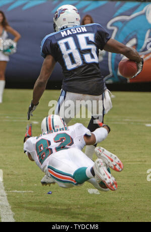 Miami Dolphins Bryan Gilmore (82) makes a diving tackle against Tennessee Titans wide receiver Derrick Mason (85) during first half action on September 11, 2004,  at Pro Player Stadium in Miami, FL. The Tennessee Titans beat the Miami Dolphins 17-7. (UPI Photo/Robert Stolpe) Stock Photo