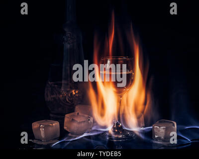 Fire on the wine glass, fire on the cocktail glass , vodka ice and fire. Stock Photo