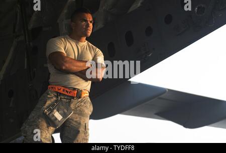 Senior Airman Zephaniah Valdez, 8th Expeditionary Air Mobility Squadron ramp transportation journeyman, watches a K-loader bearing pallets approach for loading into an 816th Expeditionary Airlift Squadron C-17 Globemaster III in support of Operation Freedom’s Sentinel Nov. 3, 2016. The operation focuses on training, advising, and assisting the Afghan Security Institutions and Afghan National Defense and Security Forces in order to build their capabilities and long-term sustainability. Stock Photo