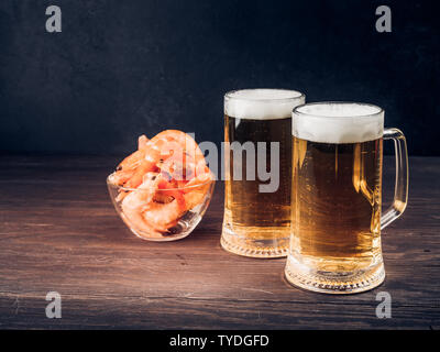 Two tall elegant pint glasses of cold wheat beer with a frothy head on a  wooden bar table conceptual of Oktoberfest Stock Photo - Alamy