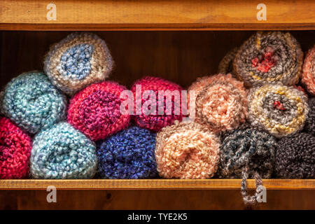 Knitting wool stacked on a shelf. Stock Photo